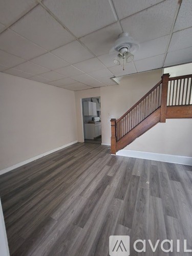 A room with wooden floors and a staircase.