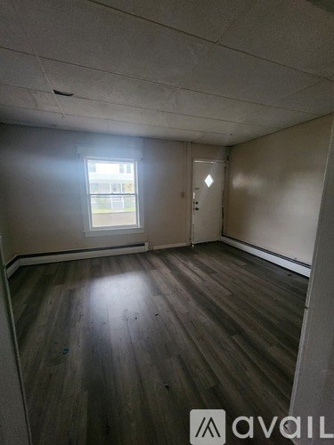 A room with wooden floors and a window letting in light.