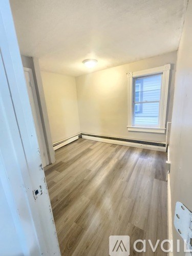 A room with wooden flooring and a window.