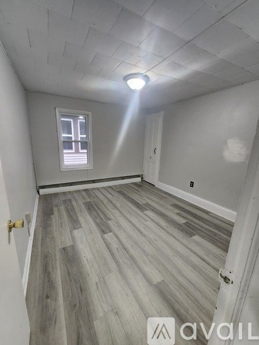 A room with wooden flooring and a window.