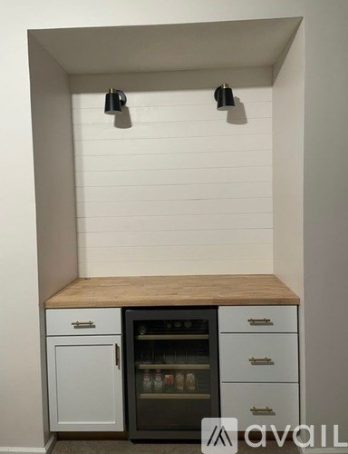 A kitchen with a white cabinet and a wooden counter top.