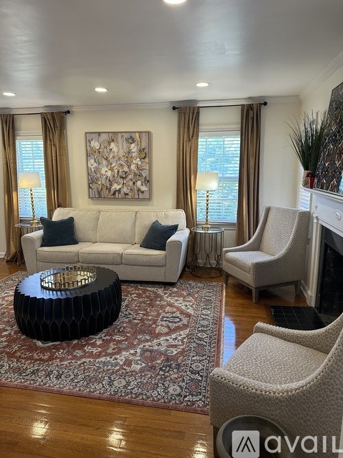 A living room with a white couch, a black coffee table, and a fireplace.