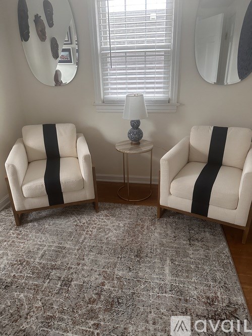 Two chairs with black stripes on them are in a room with a grey rug.