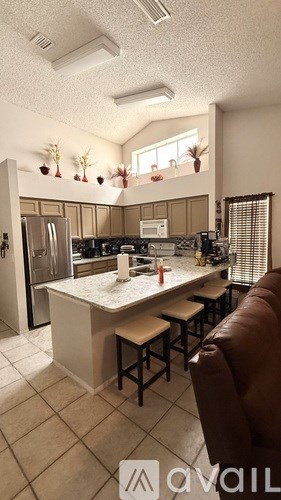 A kitchen with a white countertop and brown bar stools.