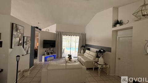 A living room with a white couch and a lamp.