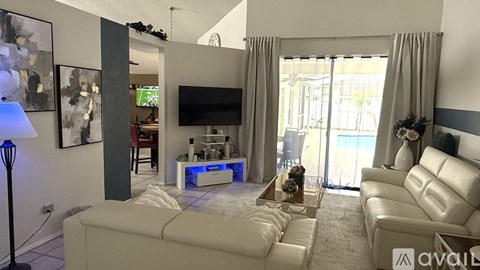 A living room with a white couch and a television.