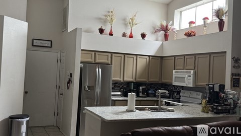 A kitchen with a white counter top and a refrigerator.