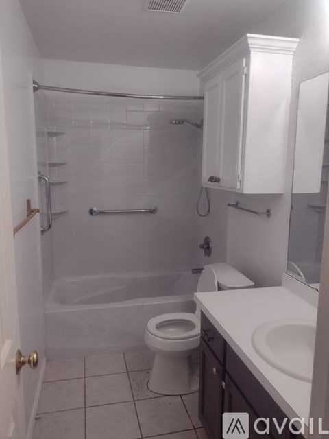 A white bathroom with a toilet, sink, and bathtub.