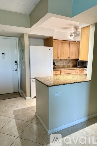 A kitchen with a white refrigerator and wooden cabinets.