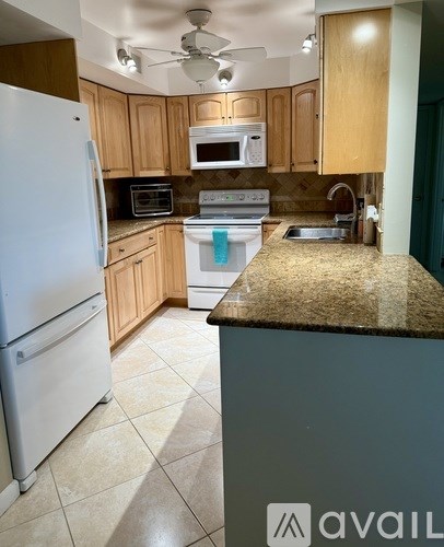 A kitchen with a white refrigerator and a counter top.