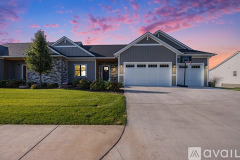 A house with a stone facade and a garage is available for sale.