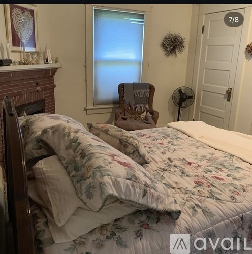 A bedroom with a bed, a chair, and a window.