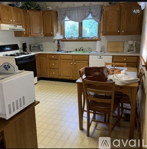 A kitchen with wooden cabinets and a white fridge.