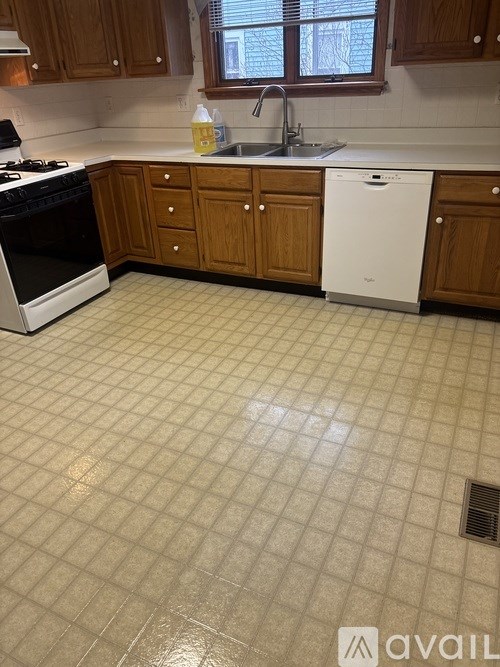 A kitchen with a white dishwasher and a black stove top.