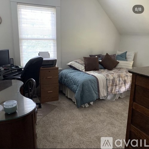 A bedroom with a bed, desk, and chair.