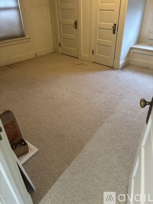 A room with a carpeted floor and white walls.
