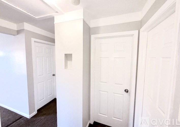 A hallway with three white doors.