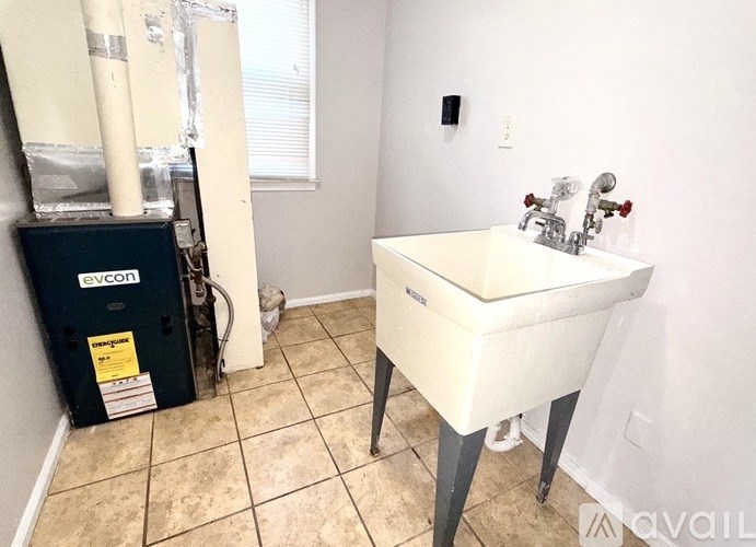 A bathroom with a white sink and a black evcon unit.