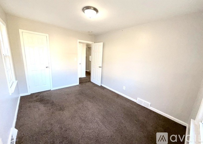 A room with carpeted floor and white walls.
