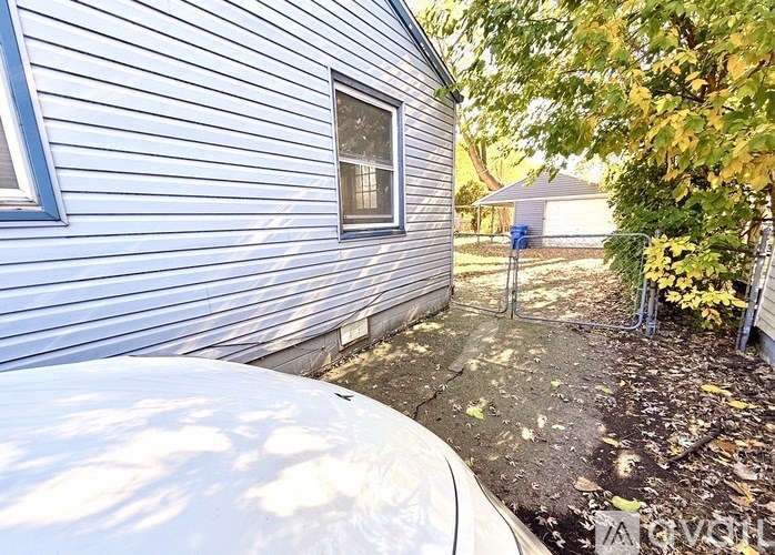 A blue house with a white car parked in front.
