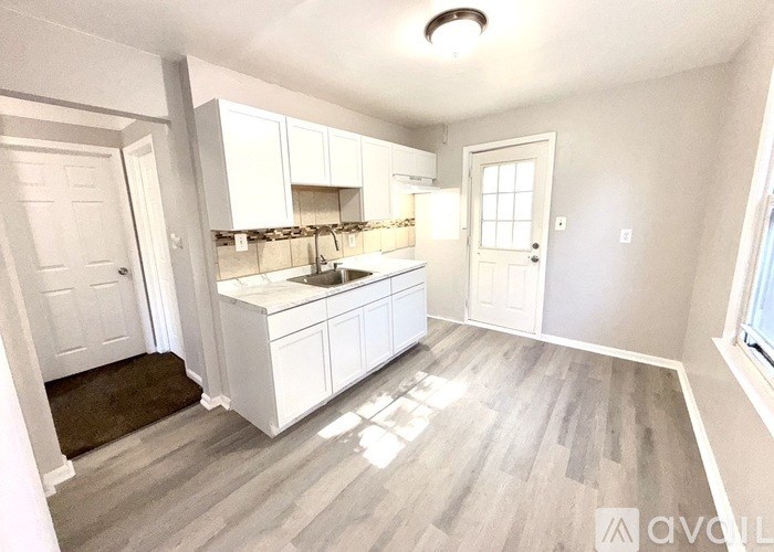 A kitchen with white cabinets and a sink.