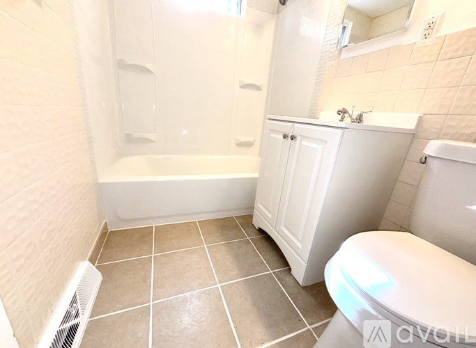 A white bathroom with a tub, sink, and toilet.