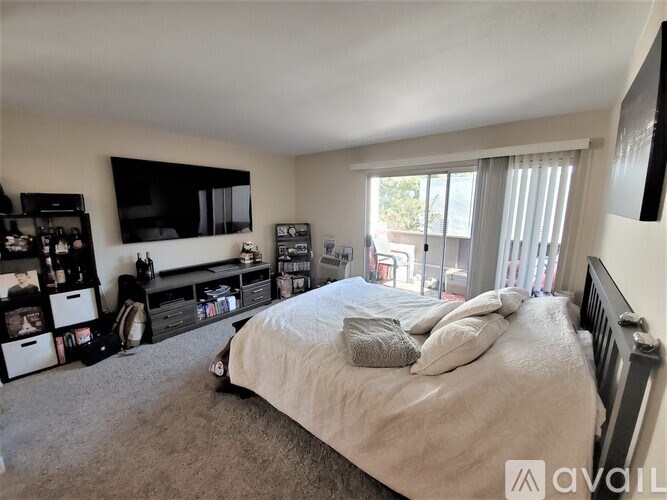 A bedroom with a large bed and a flat screen TV mounted on the wall.