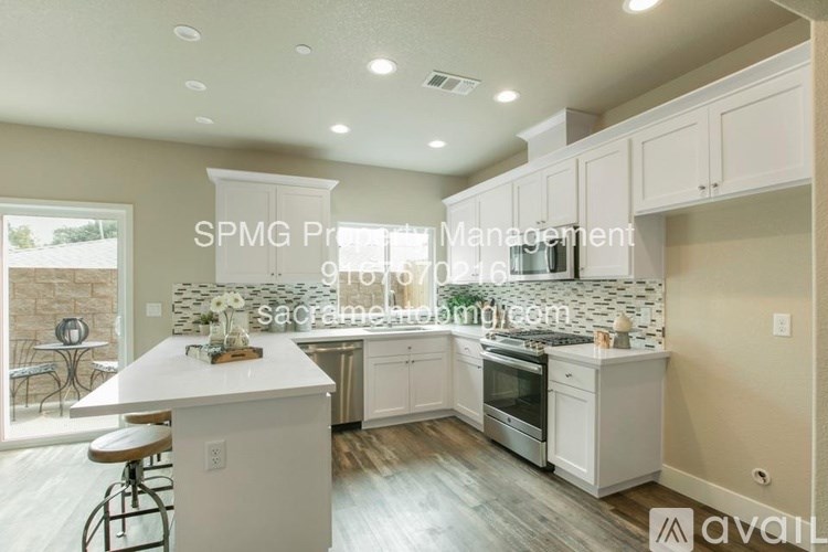 A kitchen with white cabinets and a countertop is available for rent.