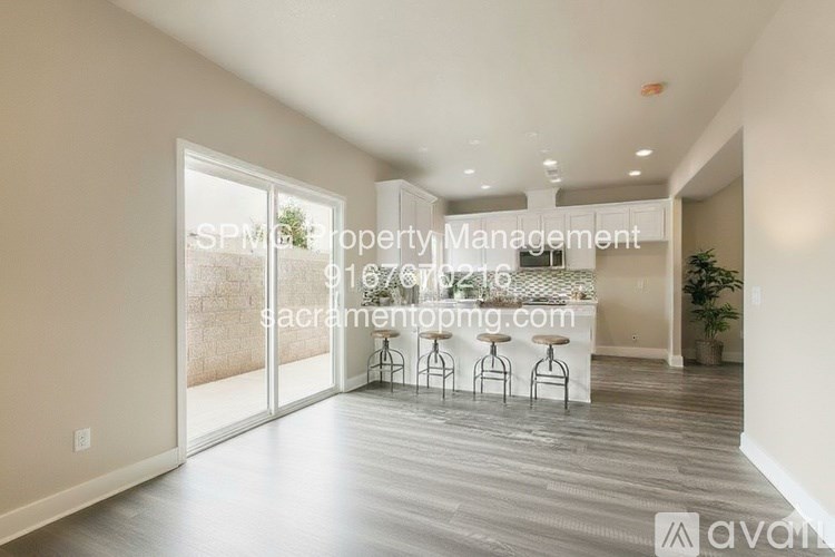 A spacious room with a bar area and a view of the outdoors through the sliding glass doors.