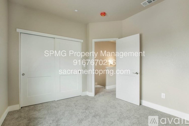 A room with a carpeted floor and two doors, one of which is open.