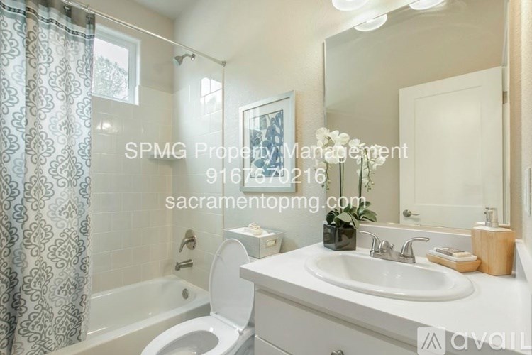 A white bathroom with a toilet, sink, and bathtub.