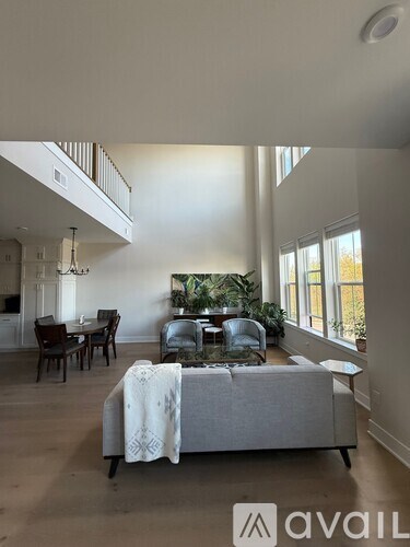 A living room with a grey couch and a dining table.