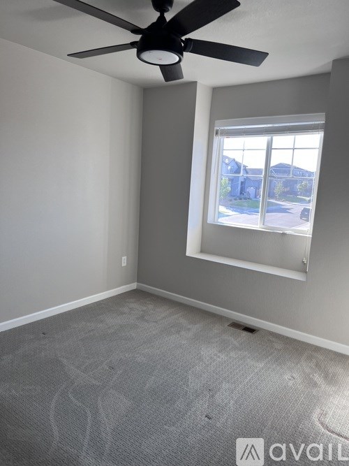A room with a ceiling fan and a window.