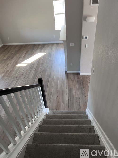 A staircase with a carpeted runner and white balusters leads to a second floor.