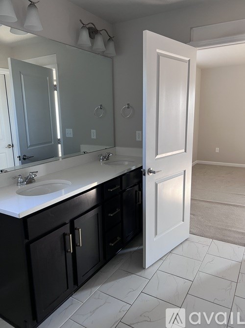 A bathroom with a sink, mirror, and cabinets.