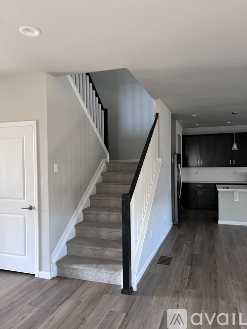 A staircase with a black railing and wooden steps.