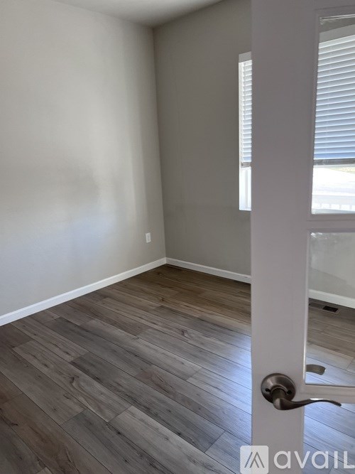 A room with a wooden floor and a white door.
