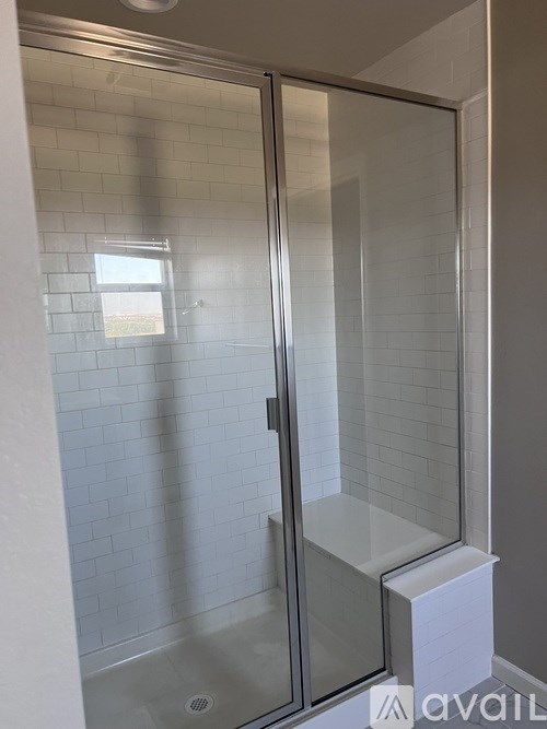 A shower with a glass door and a white base.
