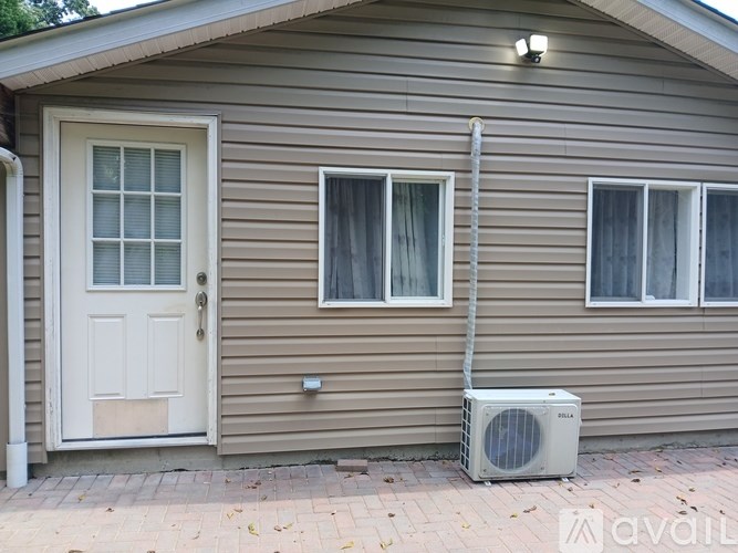 A house with a white door and a window with curtains.