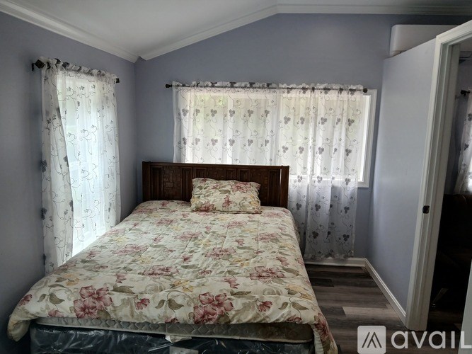 A bedroom with a floral bedspread and curtains.