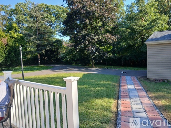 A white picket fence in front of a green lawn.
