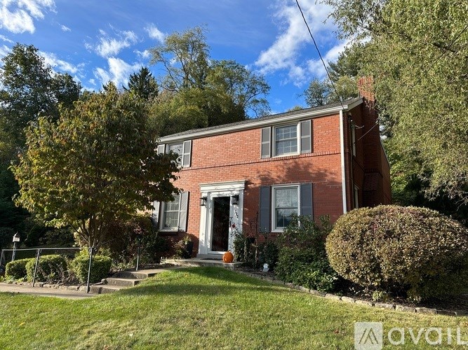 A red brick house with a white door and windows.