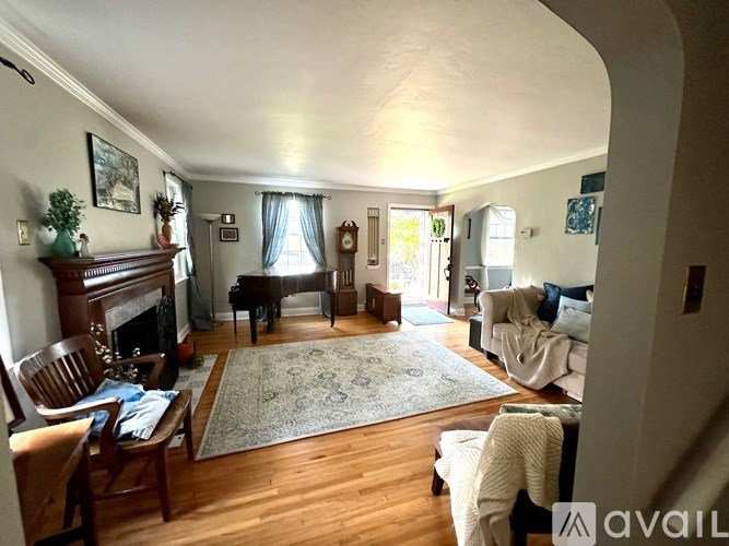 A living room with a piano and a fireplace.