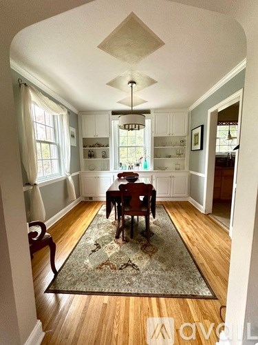 A dining room with a table and chairs.