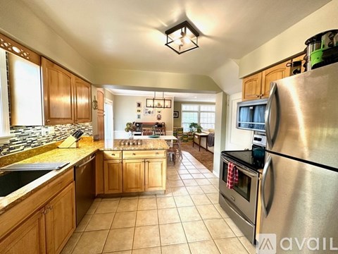 A kitchen with wooden cabinets and a stainless steel refrigerator.