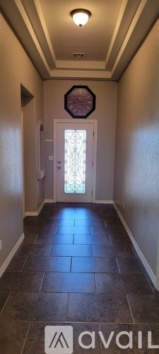 A hallway with a tiled floor and a door at the end.