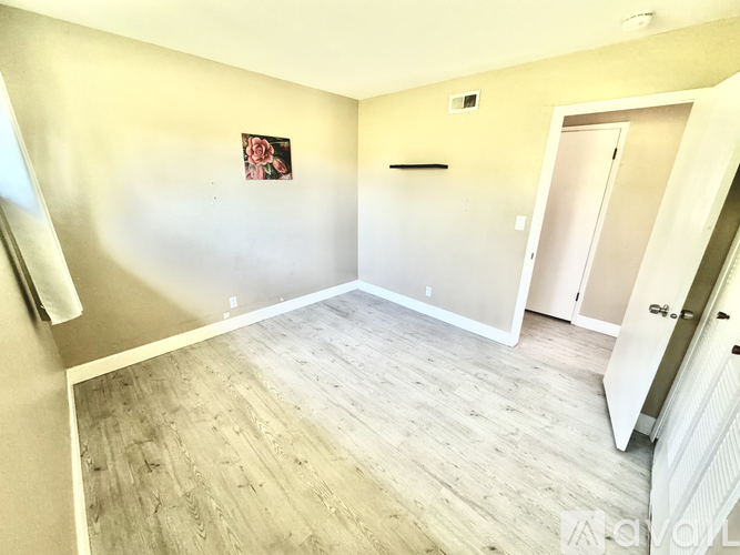 A room with wooden flooring and a white door.