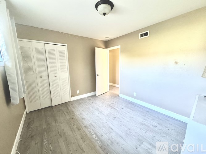 A room with a wooden floor and a white door.