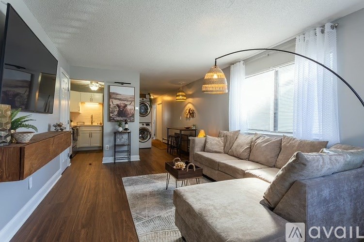 A living room with a grey couch and a wooden floor.