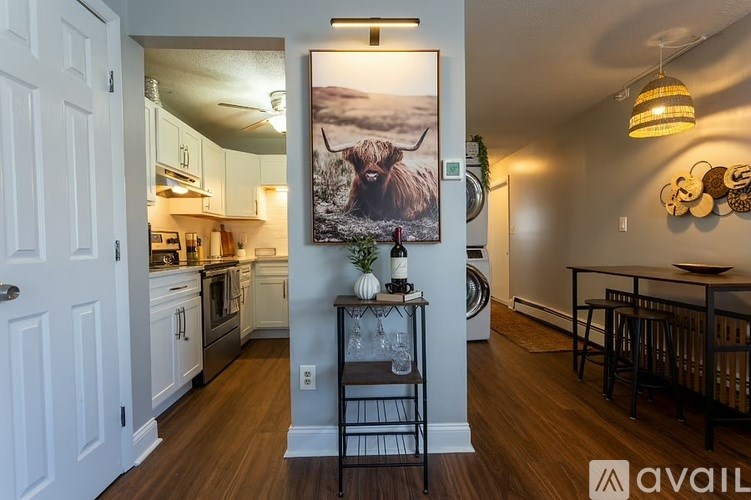 A kitchen with a painting of a moose on the wall.